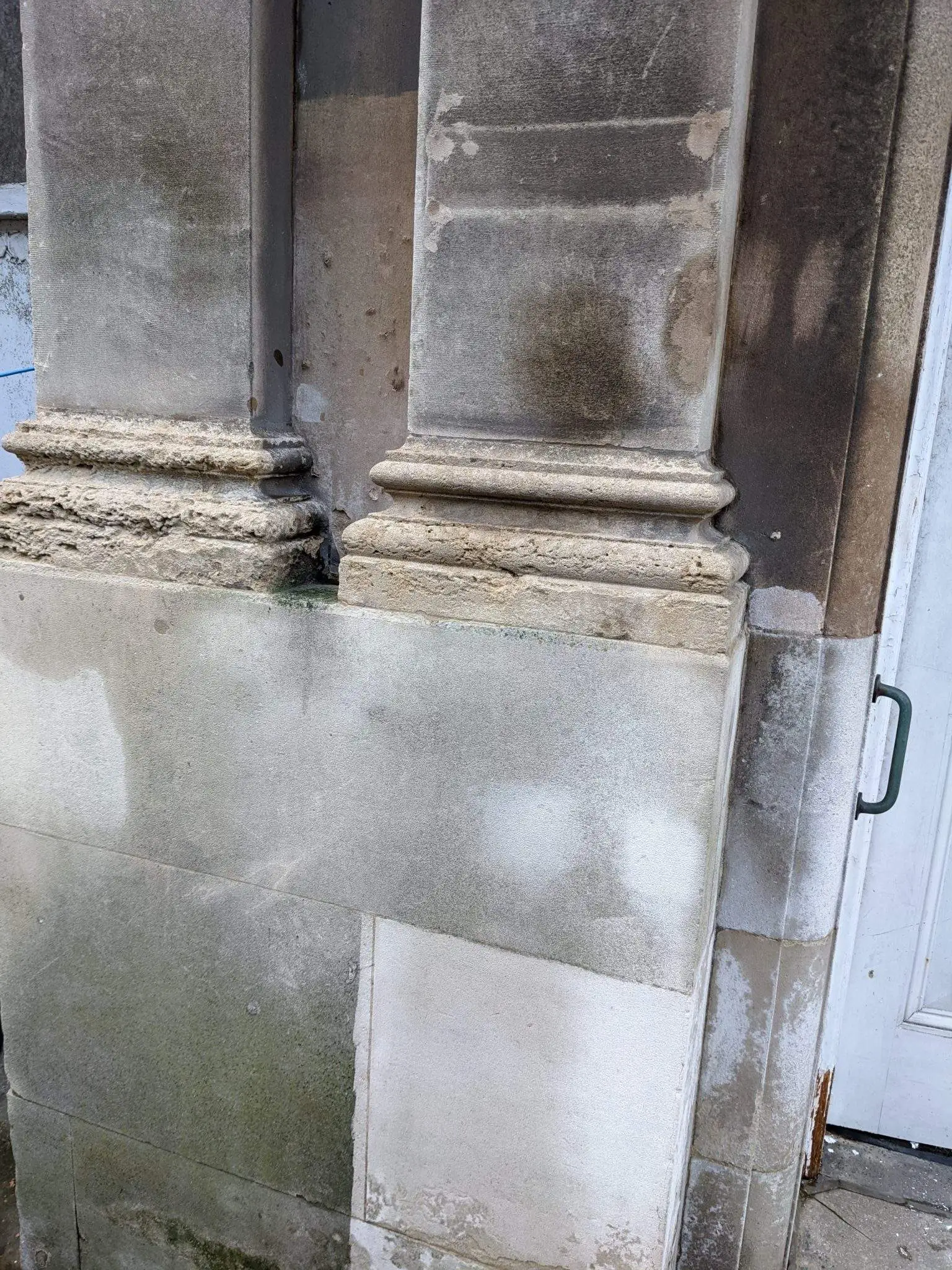 Figure 3 – Image illustrating the level of sulphation on the exterior of the Post Office at ground floor, with cleaning trials completed in January 2022 to determine an approach for cleaning of the stonework. Conservators Aldis and May used Thermatech to steam clean the surface level dirt from the building, and chemical poultices to remove the more stubborn areas of sulphation and linseed oil.