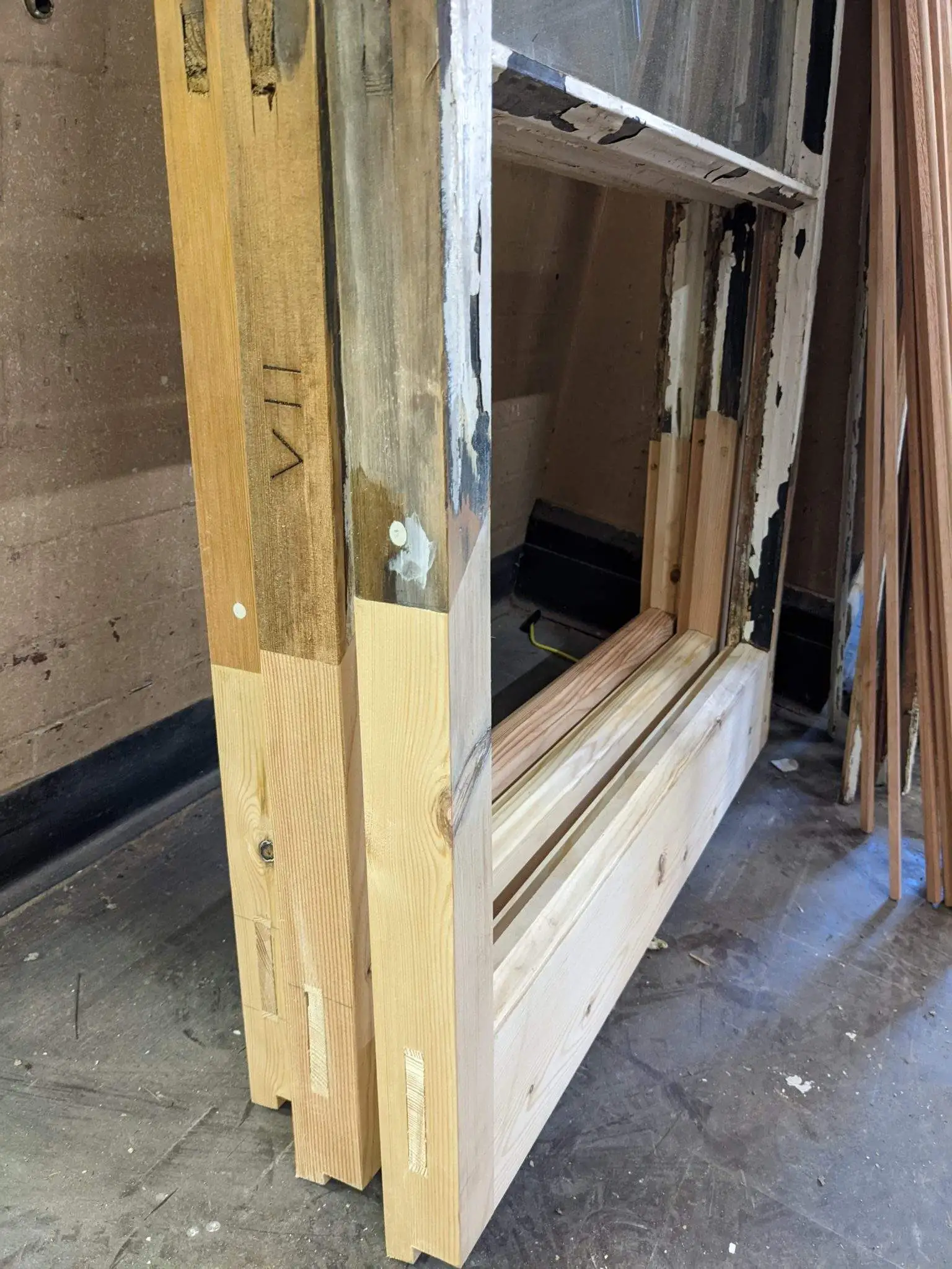 Figure 6 – Example of splice repairs completed to the original windows to replace rotten areas of timber. The original method of numbering the windows in Roman numerals can be seen on the middle sash